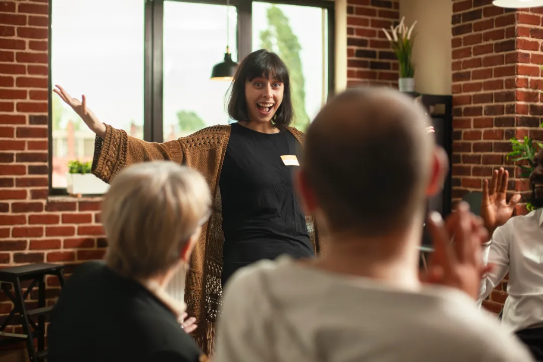 Cheerful young lady sharing good recovery news in brick wall office. 