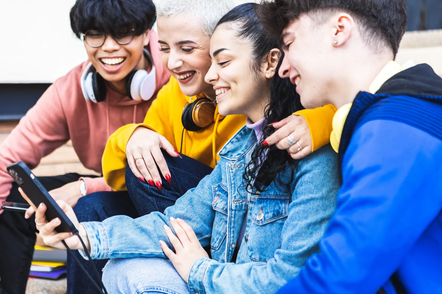 Multiracial student friends having fun watching social media content on app
